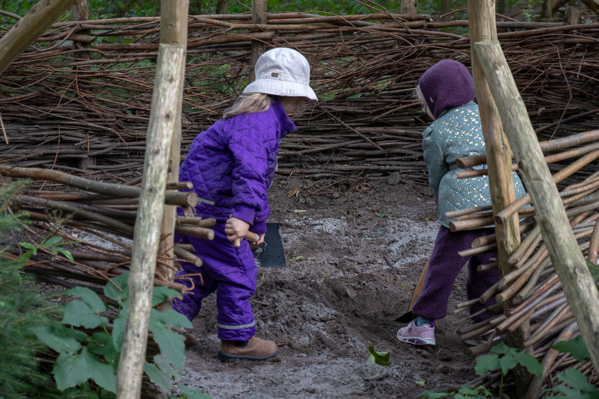Der er mange huler i skovbørnehaven. Her er 2 børn i gang med at lege i en af dem.