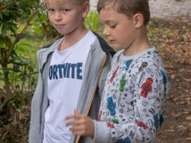 To drenge betragter deres hule i skolegården.